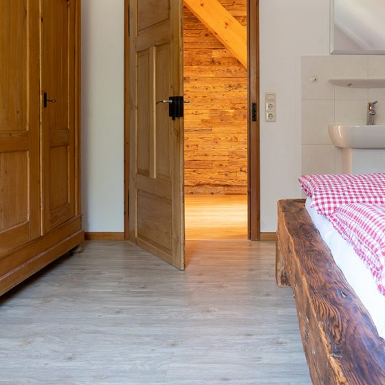 Ein Schlafzimmer der Ferienwohnung Tannengrün auf dem Schätzlehof ist mit einem extra Waschbecken ausgestattet.